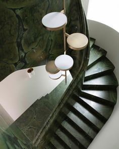 a spiral staircase in a house with green marble walls