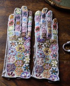 an old pair of gloves sitting on top of a wooden table next to some scissors