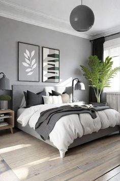 a bedroom with grey walls and white bedding in the center, two framed pictures on the wall