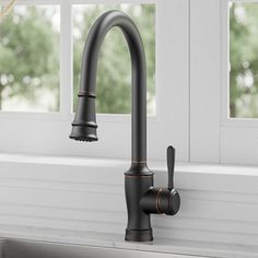 a black kitchen faucet sitting on top of a counter next to a window