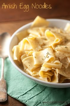 a white bowl filled with pasta on top of a green napkin