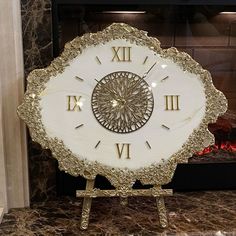 a large white clock sitting on top of a marble counter next to a fire place