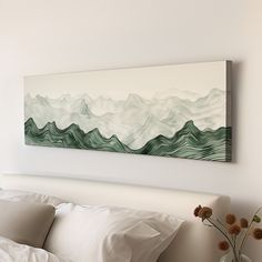 a painting hanging on the wall above a bed next to pillows and a vase with flowers