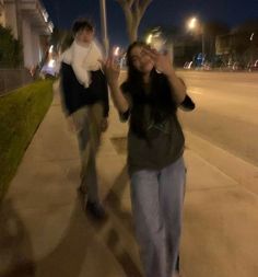 two people walking down the street at night