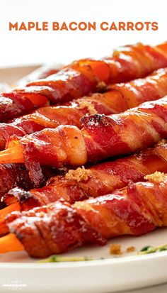 bacon wrapped carrots on a white plate