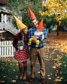 a man and woman are dressed up as gnomes with baby in their arms while standing next to each other