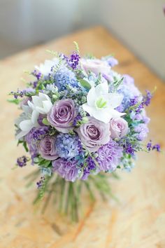 a bouquet of purple and white flowers on a table