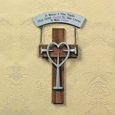 a wooden cross hanging on the side of a building with a sign that says, when women's this nails that i have christ to love it