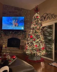 a living room with a christmas tree in the corner and a flat screen tv above it