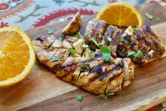 grilled meat and orange slices on a cutting board