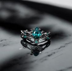 a ring with an oval cut blue topazte surrounded by small white and green diamonds