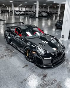 a black and red sports car parked in a parking garage