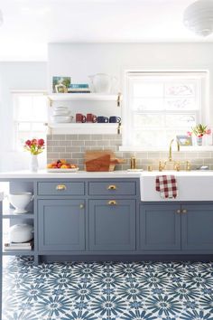 an image of a kitchen with blue cabinets and white counter tops on the phone screen