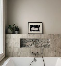 a bathtub with a shower head in the corner