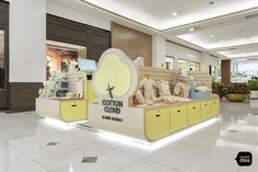 the interior of a store with yellow and white furniture