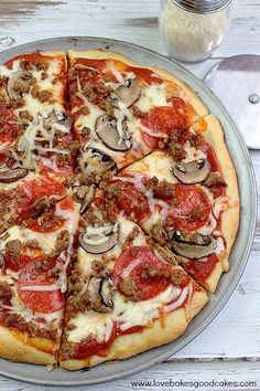 a pizza sitting on top of a pan covered in toppings