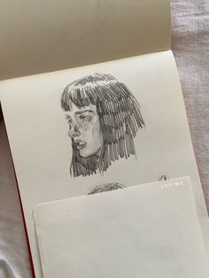 a pencil drawing of a woman's head on top of a piece of paper