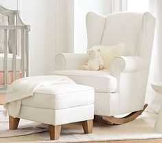 a white rocking chair and footstool in a baby's room with a teddy bear