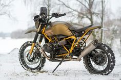 a motorcycle parked in the snow near some trees