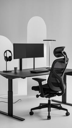 an office chair sitting in front of a computer desk with headphones on top of it