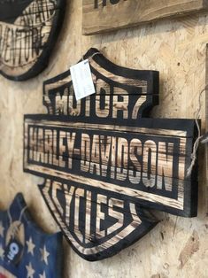 two wooden signs are hanging on the wall next to other wood plaques that say motor harley davidson