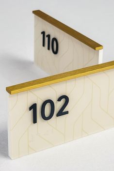 two white and gold numbered signs with numbers on them, one for the number ten