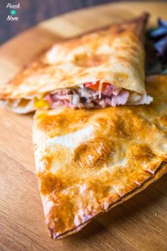 two quesadillas sitting on top of a wooden cutting board