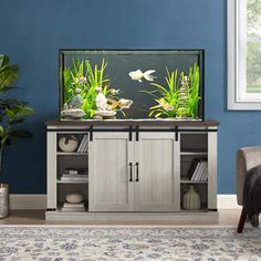 a fish tank sitting on top of a cabinet in a living room next to a chair