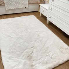 a white rug is on the floor in a room with drawers and dressers,