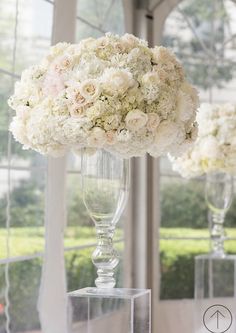 two tall vases filled with white and pink flowers