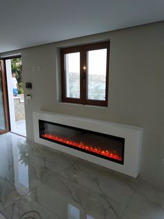 a modern fireplace in the middle of a room with marble flooring and large windows