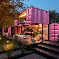 a house made out of shipping containers is lit up at night