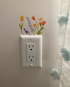 an electrical outlet with flowers painted on it