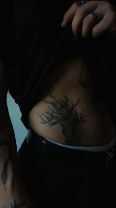 a person with tattoos on their stomach holding a cell phone