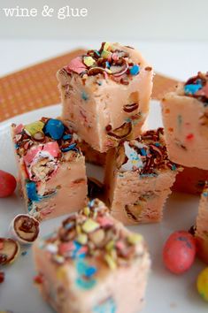 several pieces of cake sitting on top of a white plate with candy candies around it