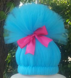 a blue wig with a pink bow on top