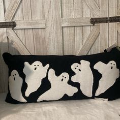 a black and white pillow with ghost silhouettes on it