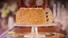 a cake with cranberry toppings on top of a glass plate sitting on a table