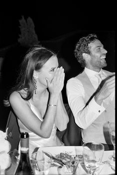 two people sitting at a table clapping