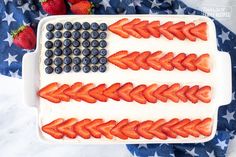 an american flag cake with strawberries and blueberries in the shape of an american flag