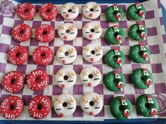 there are many doughnuts on the checkered tablecloth that have been decorated to look like people's faces