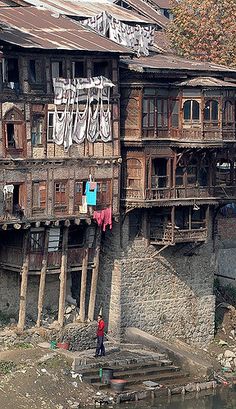 an old wooden building with clothes hanging out to dry on the balconys and windows