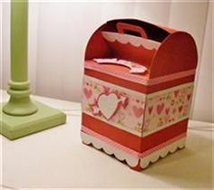 a pink and green box sitting on top of a table next to a candle holder