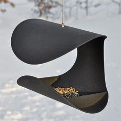 a bird feeder hanging from a tree in the snow