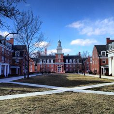 an old brick building with a clock tower in the middle of it's courtyard