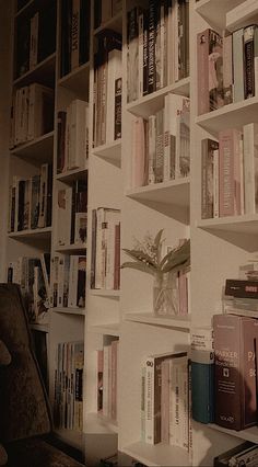 a bookshelf filled with lots of books next to a wall full of books