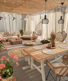 an outdoor living area with wicker furniture and flowers on the table in front of it