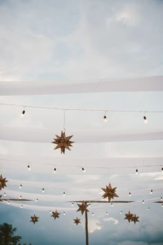 star decorations hanging from the ceiling in front of cloudy sky