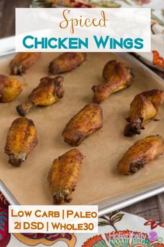 baked chicken wings on a baking sheet with the words spiced chicken wings below it