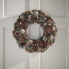 a pine cone wreath hanging on the front door